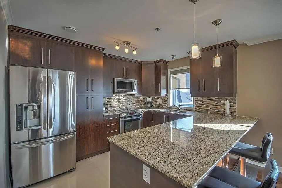 Kitchen with granite counters, stainless appliances and a mosaic backsplash
