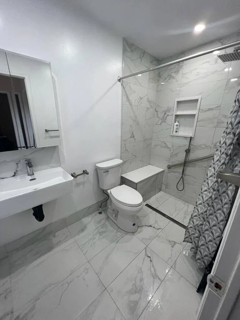 Bathroom with marble-look tile and a walk-in shower